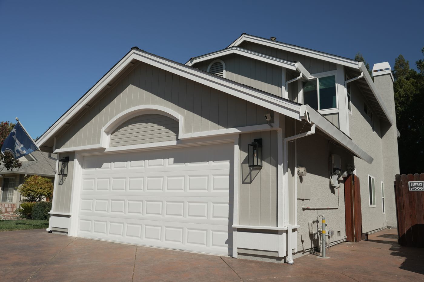 Finished garage and front gable with light siding, white trim and a white garage door.