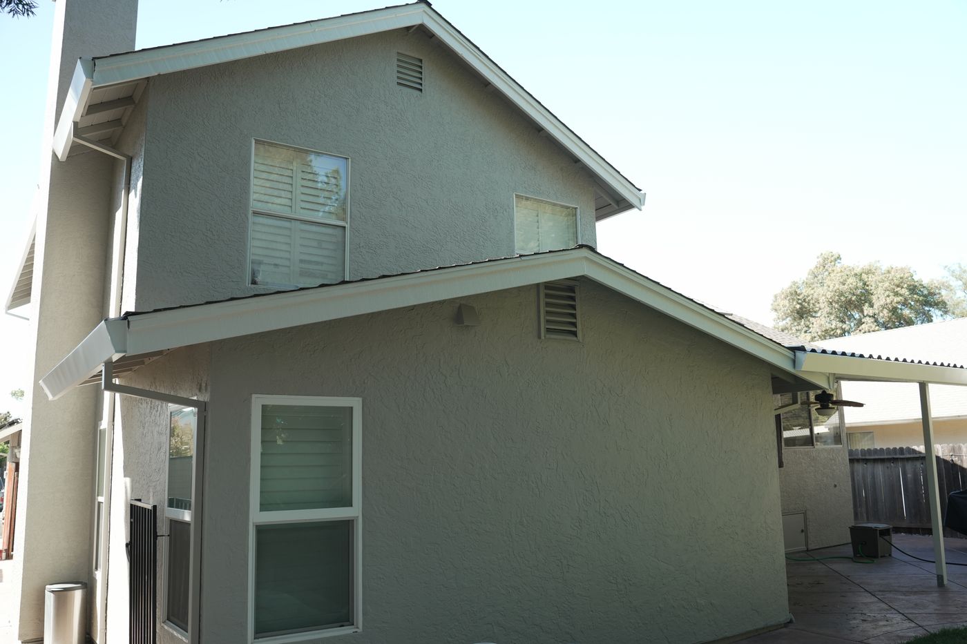 Rear of the finished home, with light gray walls and white-trimmed windows.