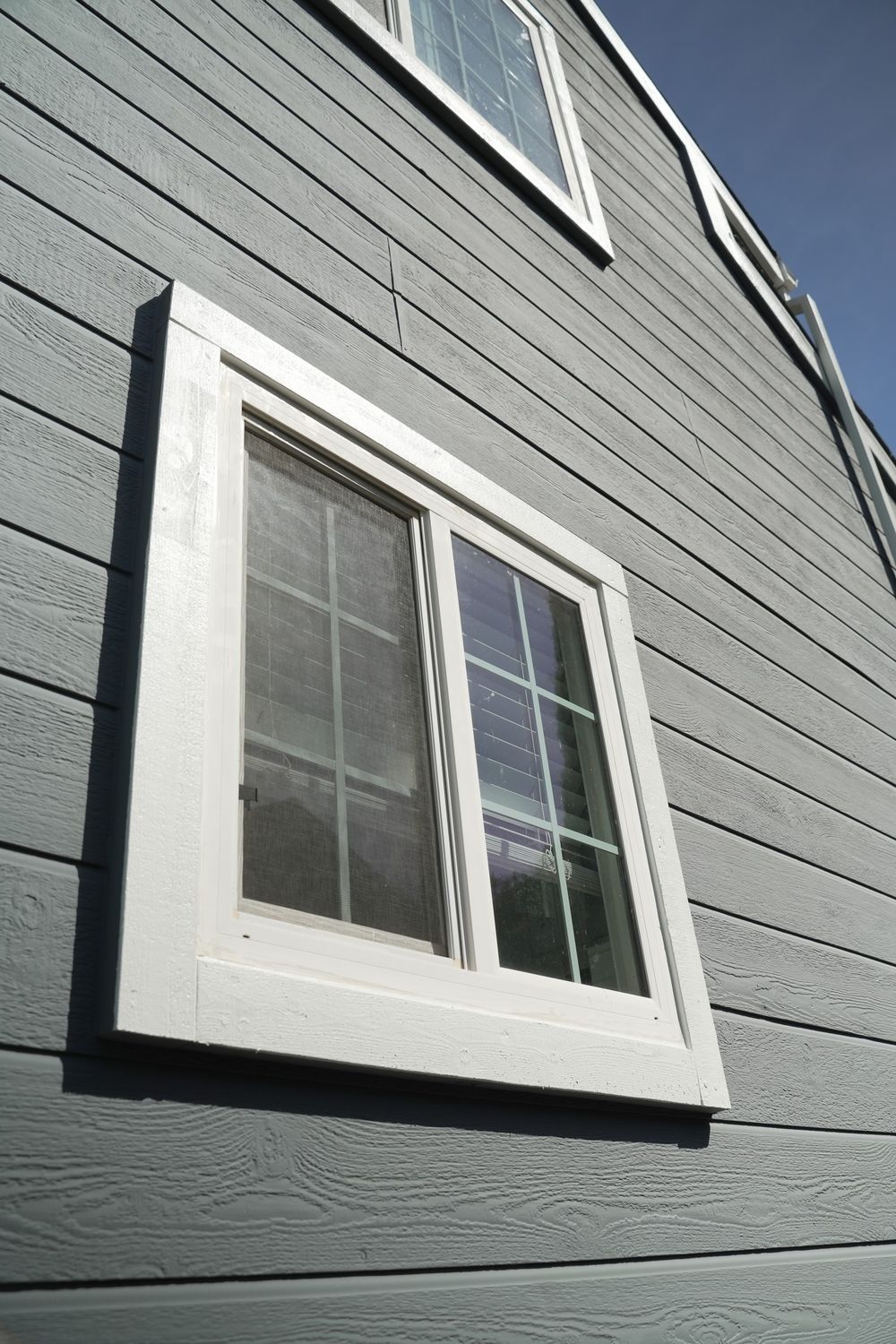 White window trim against horizontal painted siding on the project home.