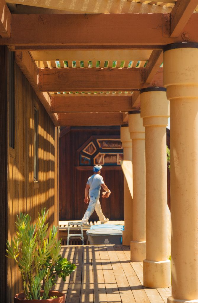 Estate porch with painted columns and stained wood siding — Milestone Painting