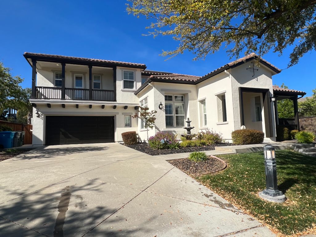 Freshly painted white stucco home exterior with dark trim