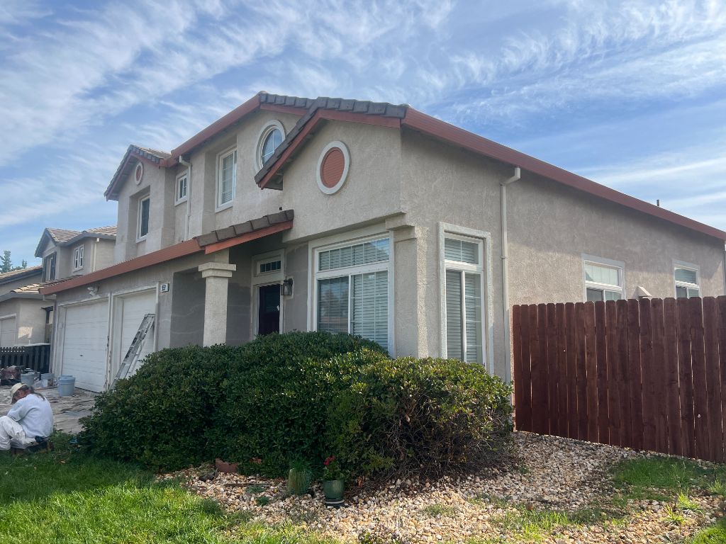 Milestone Painting crew with ladders prepping exterior of home